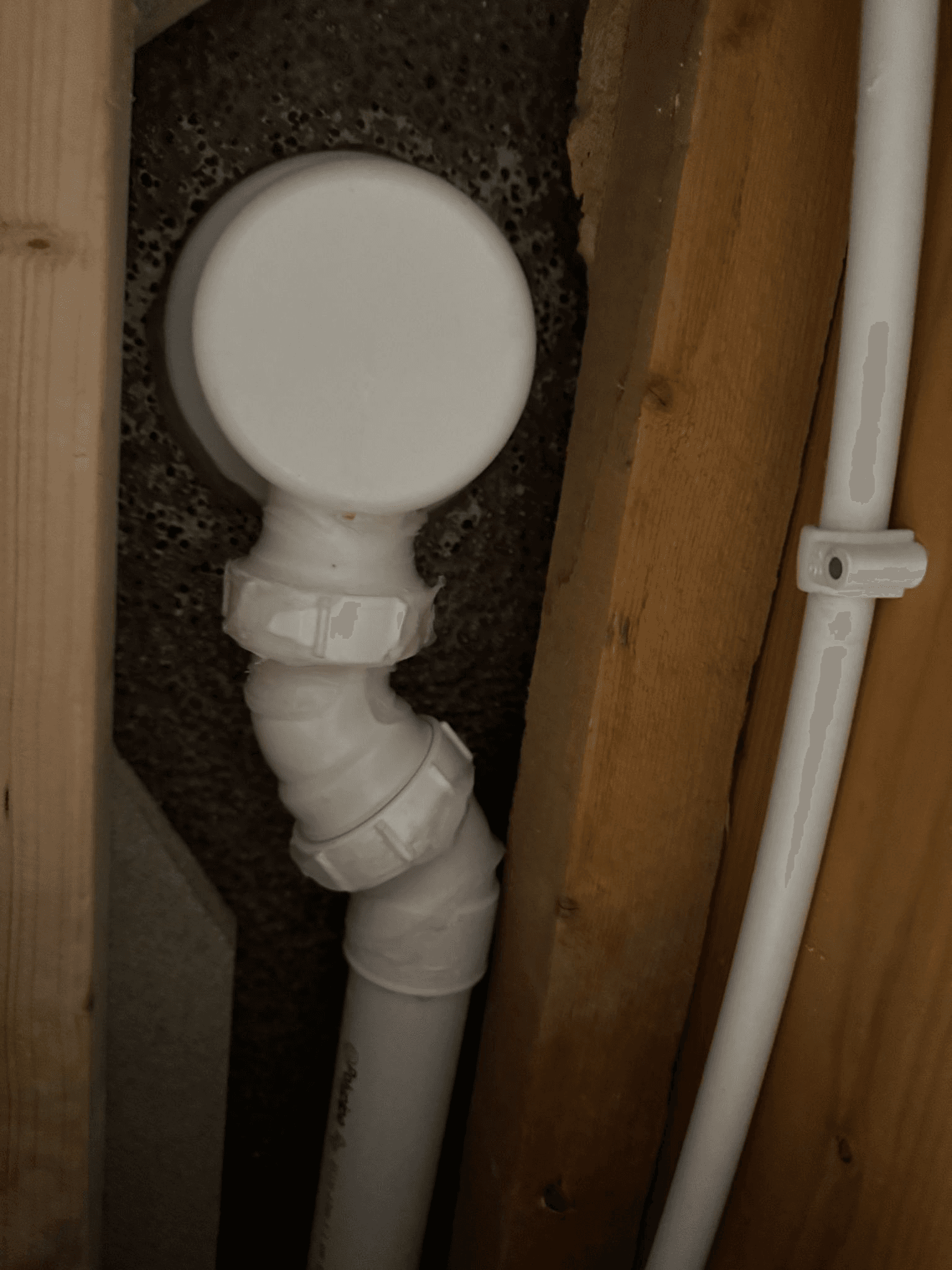 White soil pipe fitting installed in confined space